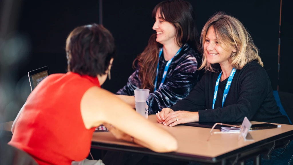 3 femmes autour d'une table ; 2 consultantes face &agrave; une com&eacute;dienne