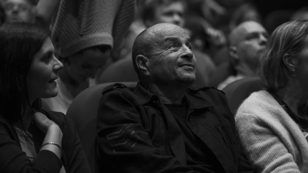 Lotfi Achour install&eacute; dans un si&egrave;ge de salle de cin&eacute;ma, les yeux riv&eacute;s sur l'&eacute;cran